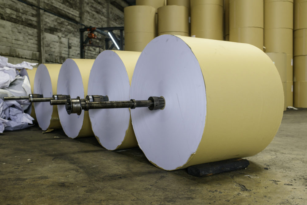 Row of paper rolls for print in a printing factory